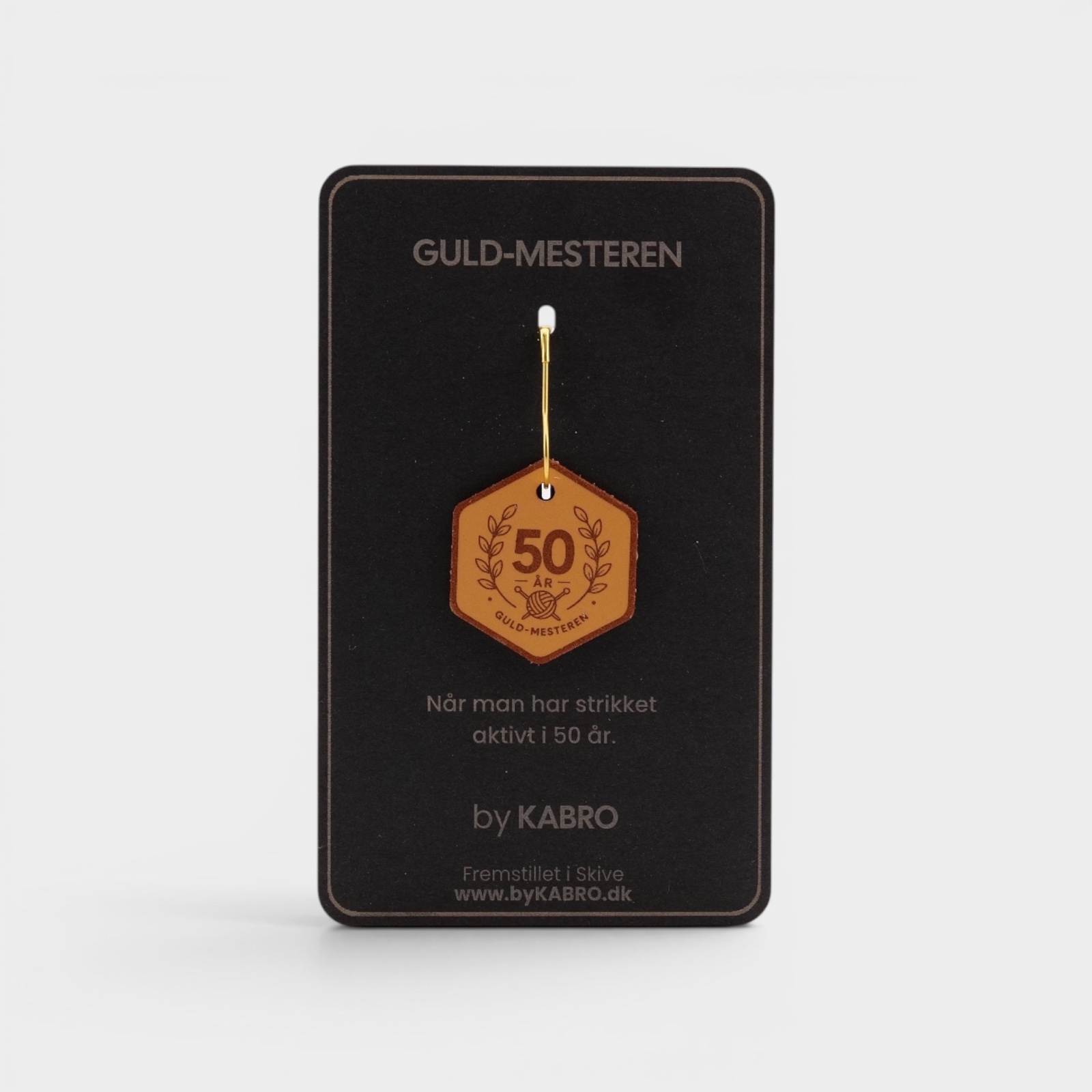 Guldmesteren – strikkemærke på sort by KABRO-kort
